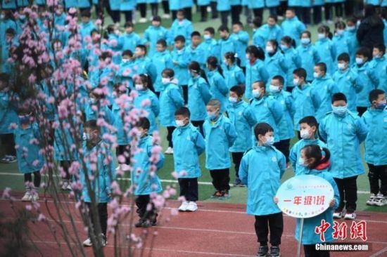 資料圖：重慶市大渡口區(qū)雙山實驗小學的學生們戴著口罩保持間隔進行開學典禮。 中新社記者 陳超 攝