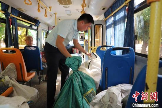 郵政工作人員在公交車上將包裹整理擺放整齊。黃文燕 攝
