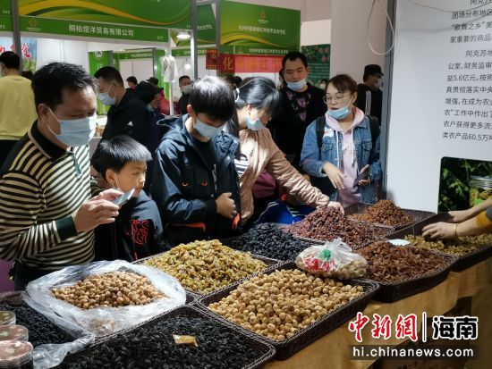 海南冬交會上全國供銷社精品館內(nèi)的農(nóng)產(chǎn)品吸引逛展觀眾購買。符宇群攝