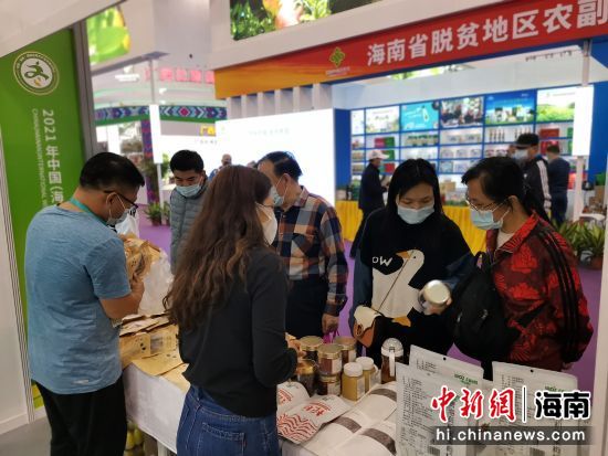 海南冬交會上全國供銷社精品館內(nèi)的農(nóng)產(chǎn)品吸引逛展觀眾購買。符宇群攝