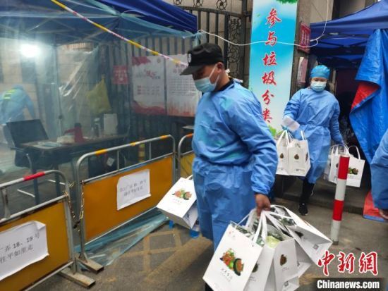 杭州一封閉管理小區(qū)，工作人員配送愛(ài)心蔬菜。　王逸飛　攝