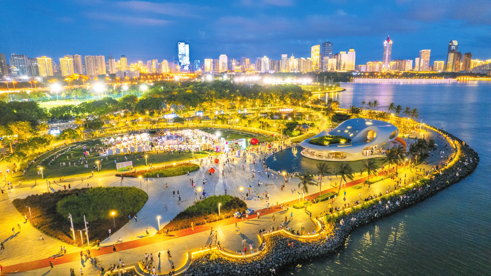 市民游客在海口灣畔暢享夏日夜晚的愜意時(shí)光。張俊其 攝