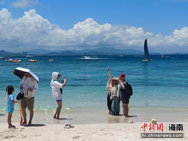 資料圖：游客在三亞蜈支洲島旅游區(qū)游玩拍照。張?jiān)潞?攝