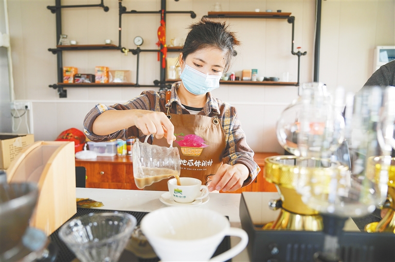 在澄邁縣橋頭鎮(zhèn)沙土村的橋沙驛站，工作人員為游客沖泡地瓜拿鐵。 李天平 攝