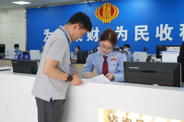 圖為稅務人員輔導海南百邁科醫(yī)療科技股份有限公司辦稅人員填報FDA外國小企業(yè)資質(zhì)收入證明相關(guān)材料。錢美伊 攝