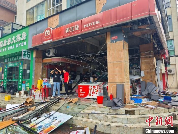 9月7日，海南�？�，一家便利店的店員在查看被超強(qiáng)臺風(fēng)“摩羯”損壞的店面。中新網(wǎng)記者 王子謙攝