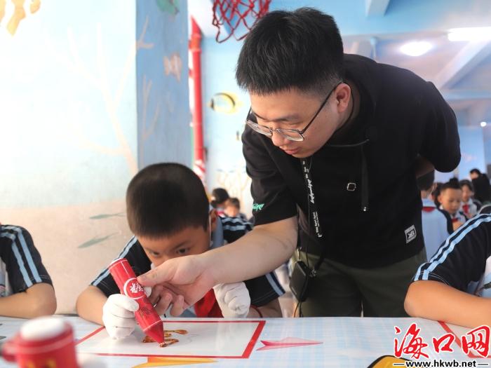 老師手把手帶著孩子一同體驗(yàn)糖畫。史子楊 攝